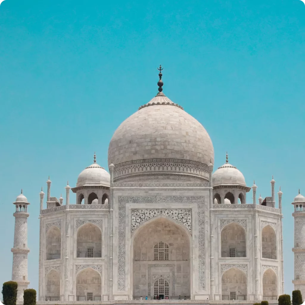 This image features the Taj Mahal, a renowned UNESCO World Heritage Site located in Agra, India. Known for its stunning white marble architecture, this mausoleum was commissioned in 1632 by the Mughal emperor Shah Jahan to house the tomb of his favorite wife, Mumtaz Mahal.