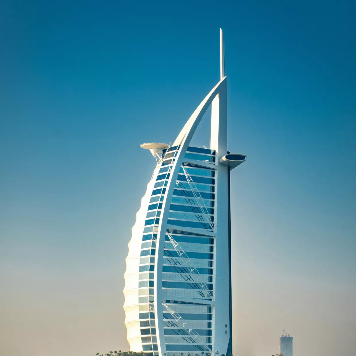 The image depicts the Burj Al Arab, a luxury hotel in Dubai, United Arab Emirates, known for its distinctive sail-shaped silhouette. The iconic structure stands on an artificial island and is often regarded as one of the most recognizable landmarks in the world.