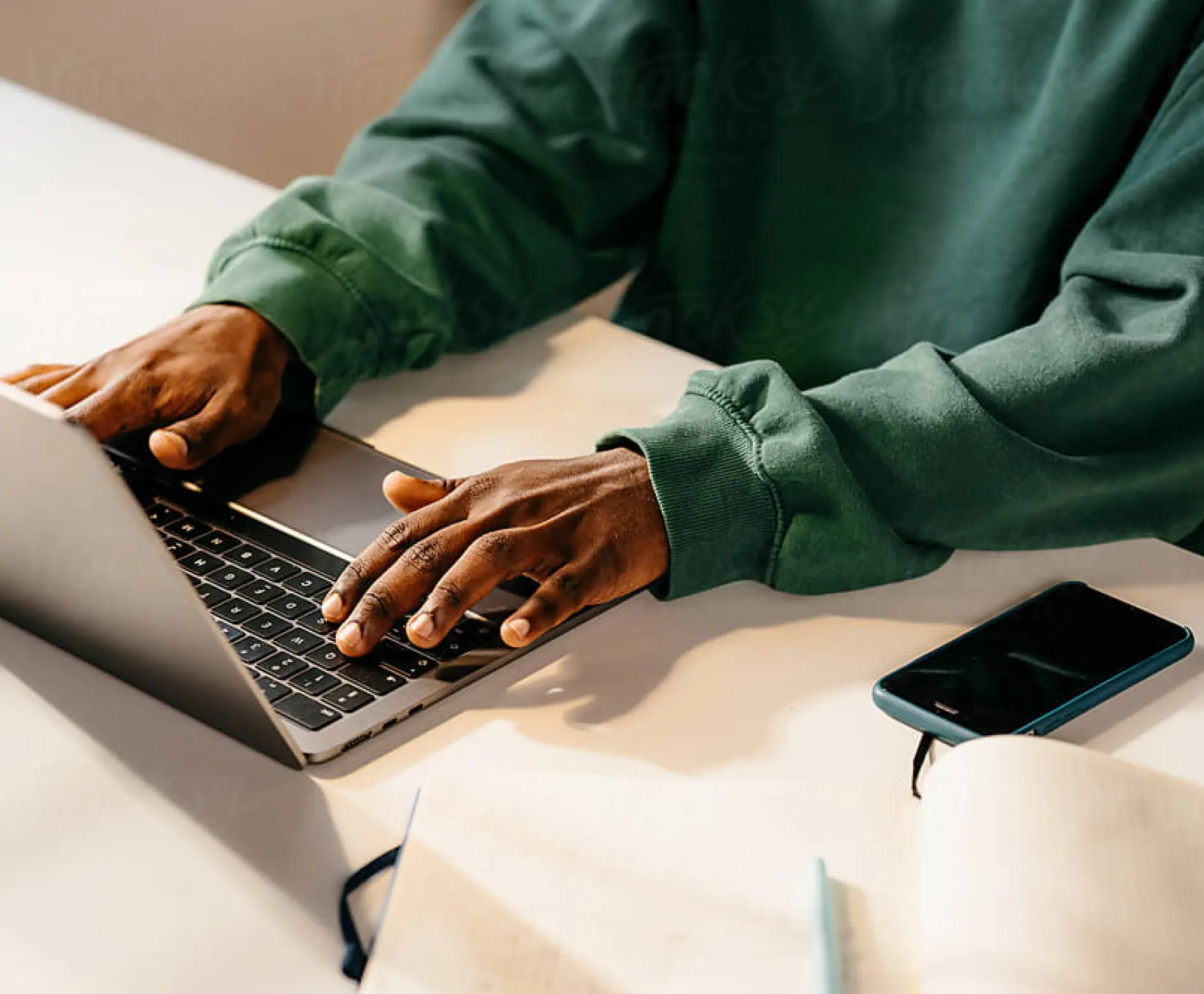 A man diligently typing on his laptop at a desk, showcasing a productive work atmosphere